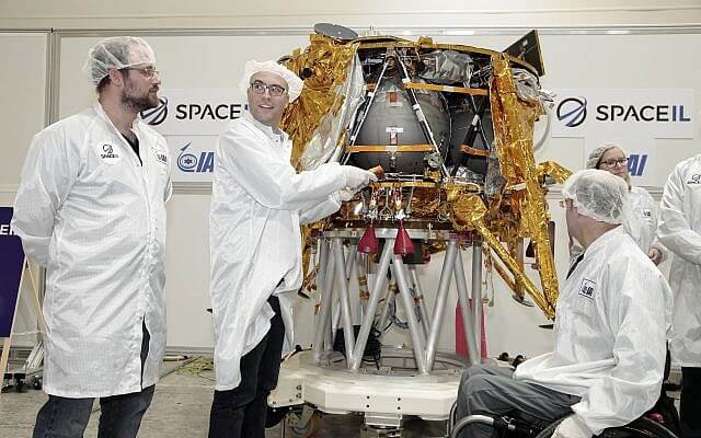 Yariv Bash, right, Yonatan Winetraub, middle, and Kfir Damari, the founders of SpaceIL, inserting a digital time capsule into the Beresheet spacecraft, December 17, 2018. (Yoav Weiss)